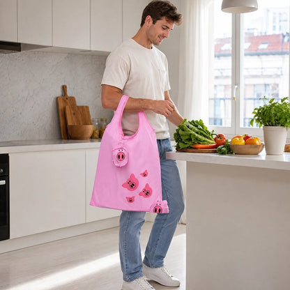 jeune-homme-souriantt-vetu-dun-t-shirt-blanc-et-dun-jean-bleu-range-des-legumes-frais-dans-une-cuisine-moderne-et-lumineuse-il-porte-au-bras-un-grand-sac-de-courses-reutilisable-rose-decorer-de-petits-cochons-rose
