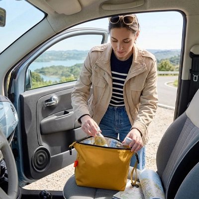 une-femme-range-des-aliments-dans-un-Sac-isotherme-jaune-moutarde-poser-sur-le-siege-dune-voiture-compacte-et-pratique-il-est-ideal-pour-les-voyages-les-pique-nique-et-les-deplacements
