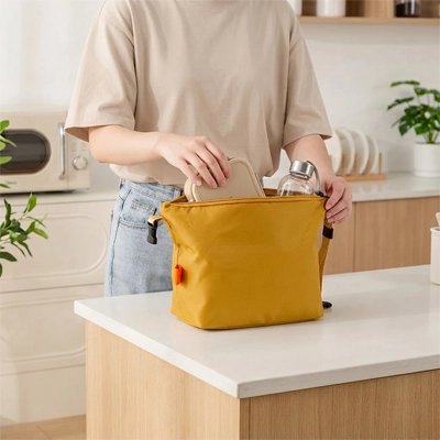 une-personne-prepare-son-sac-isotherme-jaune-moutarde-dans-une-cuisine-moderne-compact-et-pratique-il-est-ideal-pour-transporter-ses-repas-et-collations-au-quotidien