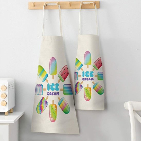 deux-tabliers-accrocher-affichent-une-illustration-colorer-et festive-sur-le-theme-des-laces-au-centre-inscription-ice-cream-en-lettre-bleues-et-violettes-autour-de-ce-texte-plusieurs-glaces-a-leau-multicolores